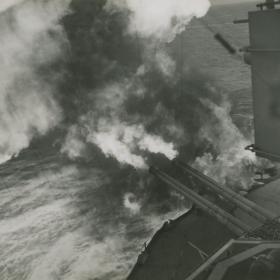 U.S.S. Nevada pours an obliterating hail of death on Nazi positions blocking the forward surge of Allied troops in France.