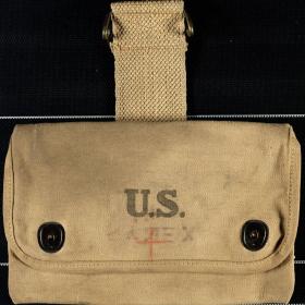 This particular pouch may have been used to carry medical equipment, as evidenced by the red cross drawn on the front.