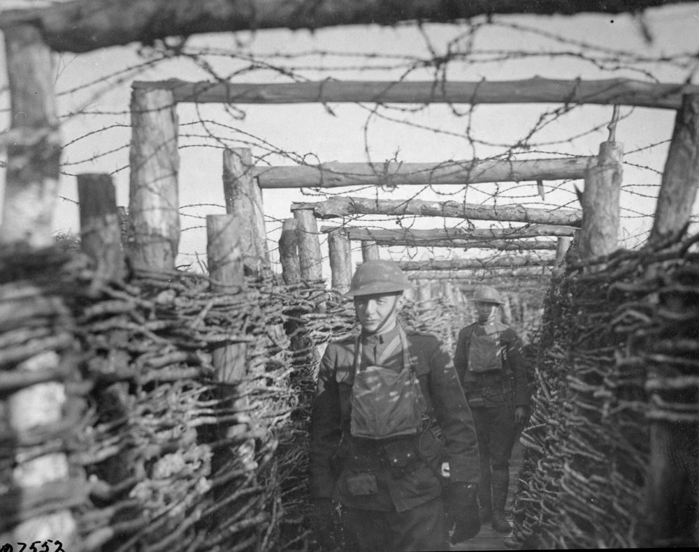 Soldiers from 166th Infantry Regiment passing through a trench.