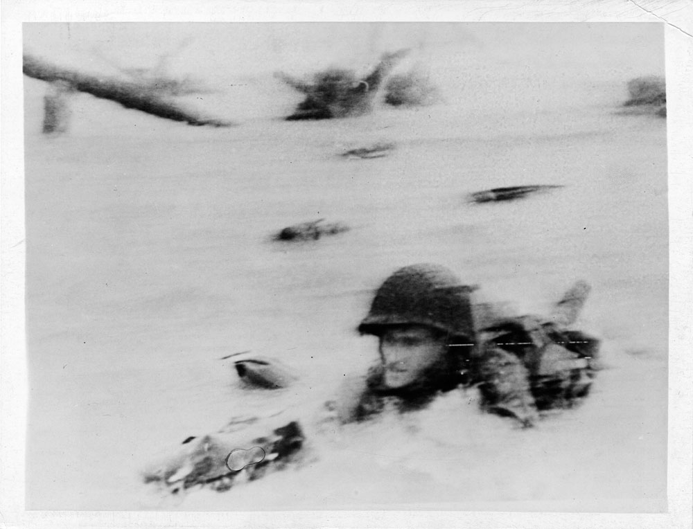 This doughboy shows how to go through breast high water under heavy artillery and machine gun fire on the French coast.