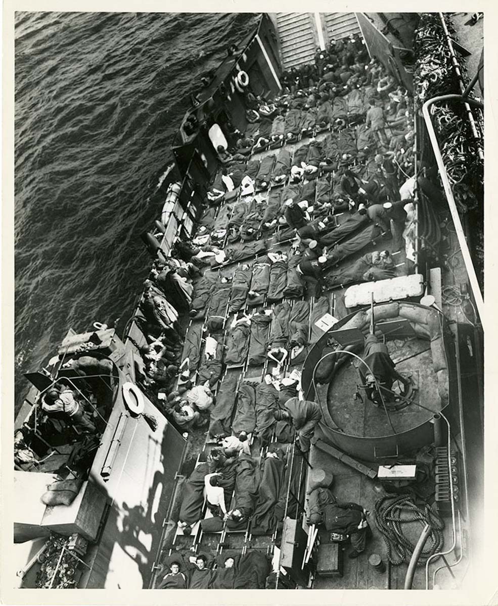 Row and row of stretchers cover the decks of a Coast Guard LCT (Landing Craft Tank) bringing out wounded invaders from the flaming soil of France.