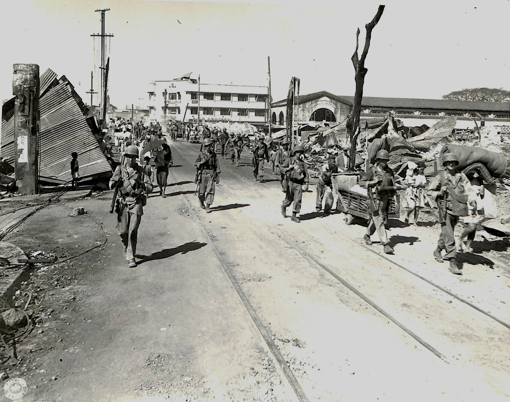 Troops walking through destroyed Manila, Philippines.