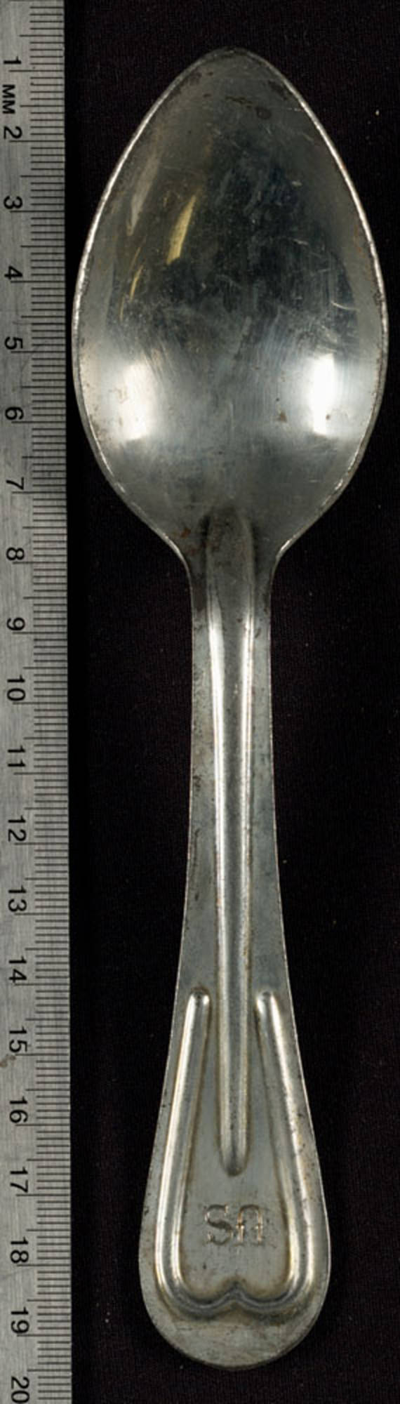 Metal spoon has "US" stamped onto the top of the handle. On the reverse side is "W.B.D." and the year, "1918."