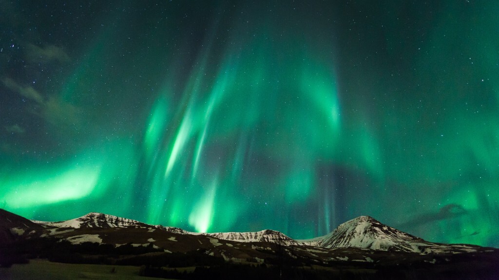 Northern Lights over snow-capped mountains in Iceland