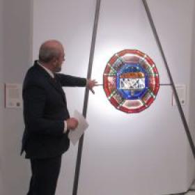 Curator pointing at stained glass artwork
