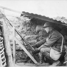 Soldier in a trench operating a signal gun. 