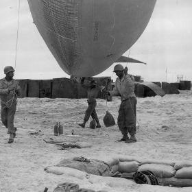 Soldiers of the 320th Barrage Balloon Battalion prepare to deploy a balloon on Omaha Beach.