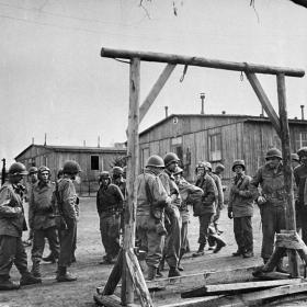 American liberators view gallows that were erected between barracks at Ohrdruf concentration camp.