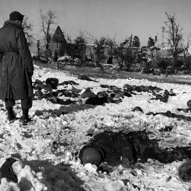 A soldier looks on at a field of American soldiers massacred by the Nazis.  
