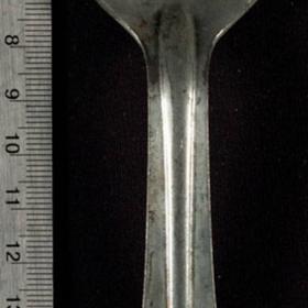 Metal spoon has "US" stamped onto the top of the handle. On the reverse side is "W.B.D." and the year, "1918."